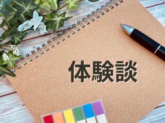 「体験談」と書かれたノートとボールペンの画像。50代未経験から営業職に転職した実例紹介の場面に適している。
