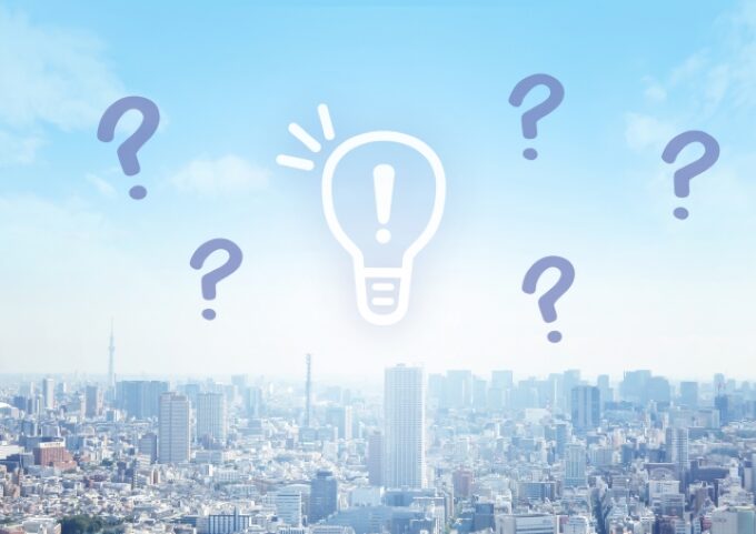 「50代未経験から営業職に挑戦できる理由」を考えるイメージ|都市の風景と疑問・ひらめきのアイコン