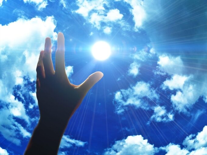 青空と太陽に向かって手を伸ばす様子。営業経験がある50代が再起を目指し、逆転のチャンスをつかもうとするイメージ。